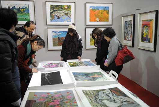 观众在一个展位前欣赏高仿真的书画复制作品