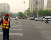 一位协管员无奈地看着闯红灯的老太太