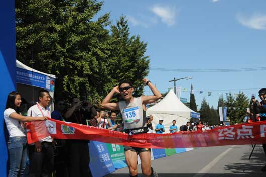 来自中国地质大学的研究生杨家根冲过100公里比赛终点线